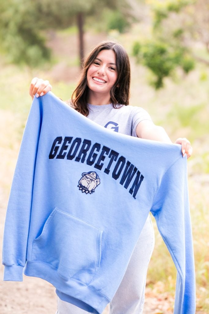 Samantha Garcia holding a blue Georgetown sweatshirt