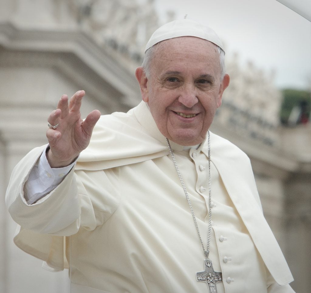 Pope Francis smiles and waves