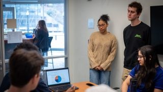 Students watch a high school present a slide deck in a breakout room