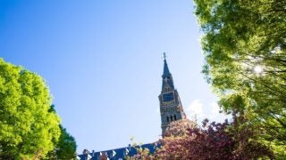 Healy Hall clocktower surrounded by pink blossoms