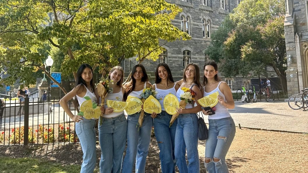 Six young girls holding name tags on a sunny day on Healy Lawn