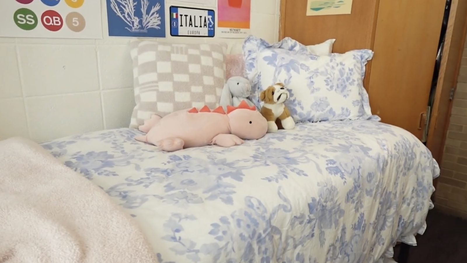 Stuffed animals on a bed in a dorm room