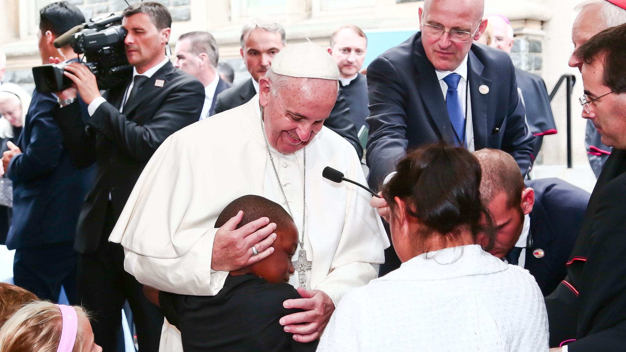 Pope Francis greets and hugs a child
