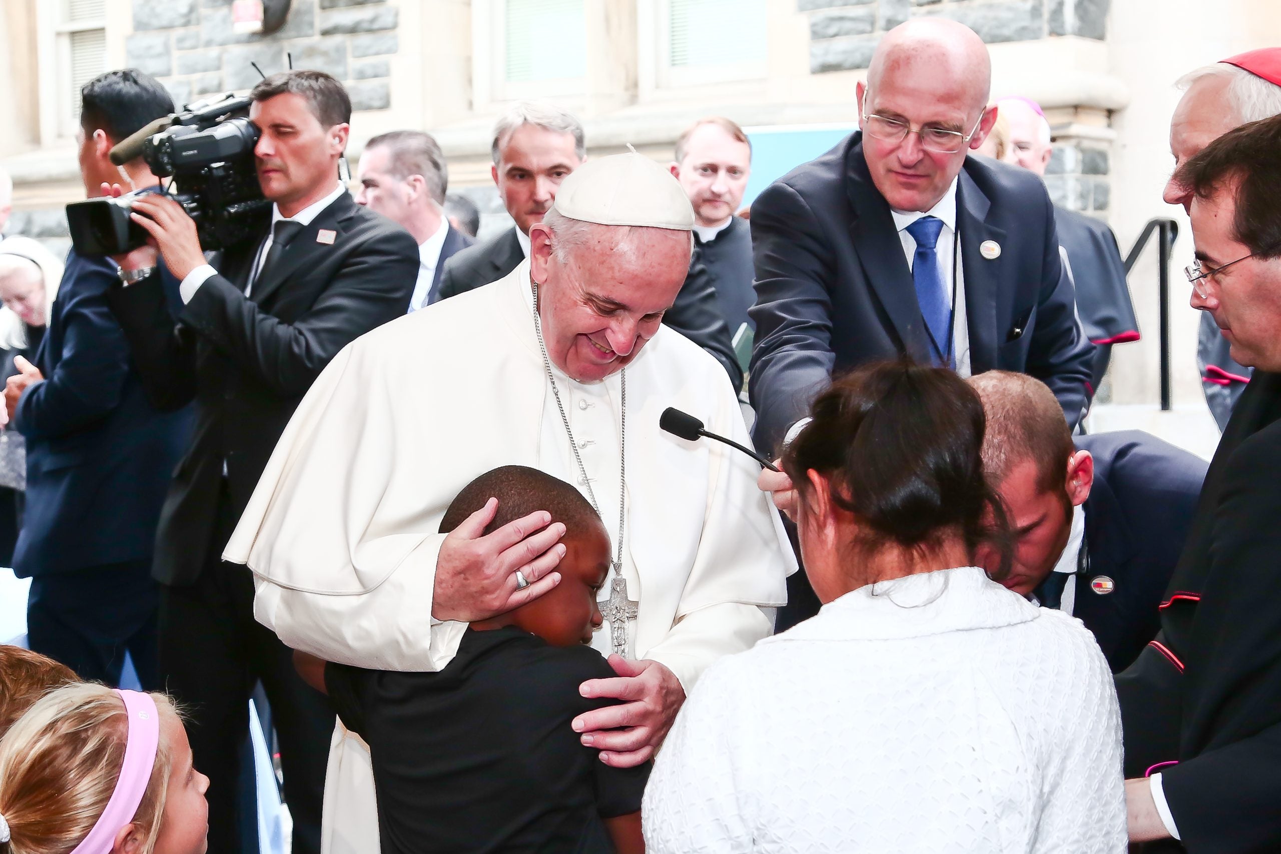 Pope Francis greets and hugs a child