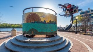 A ringed art installation along the Potomac River with the sun shining down on it