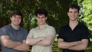 John Andrzejewski (C&#039;25), Eli Kerstein (C&#039;24) and Lucas Raskin wearing polo shirts and smiling at the camera