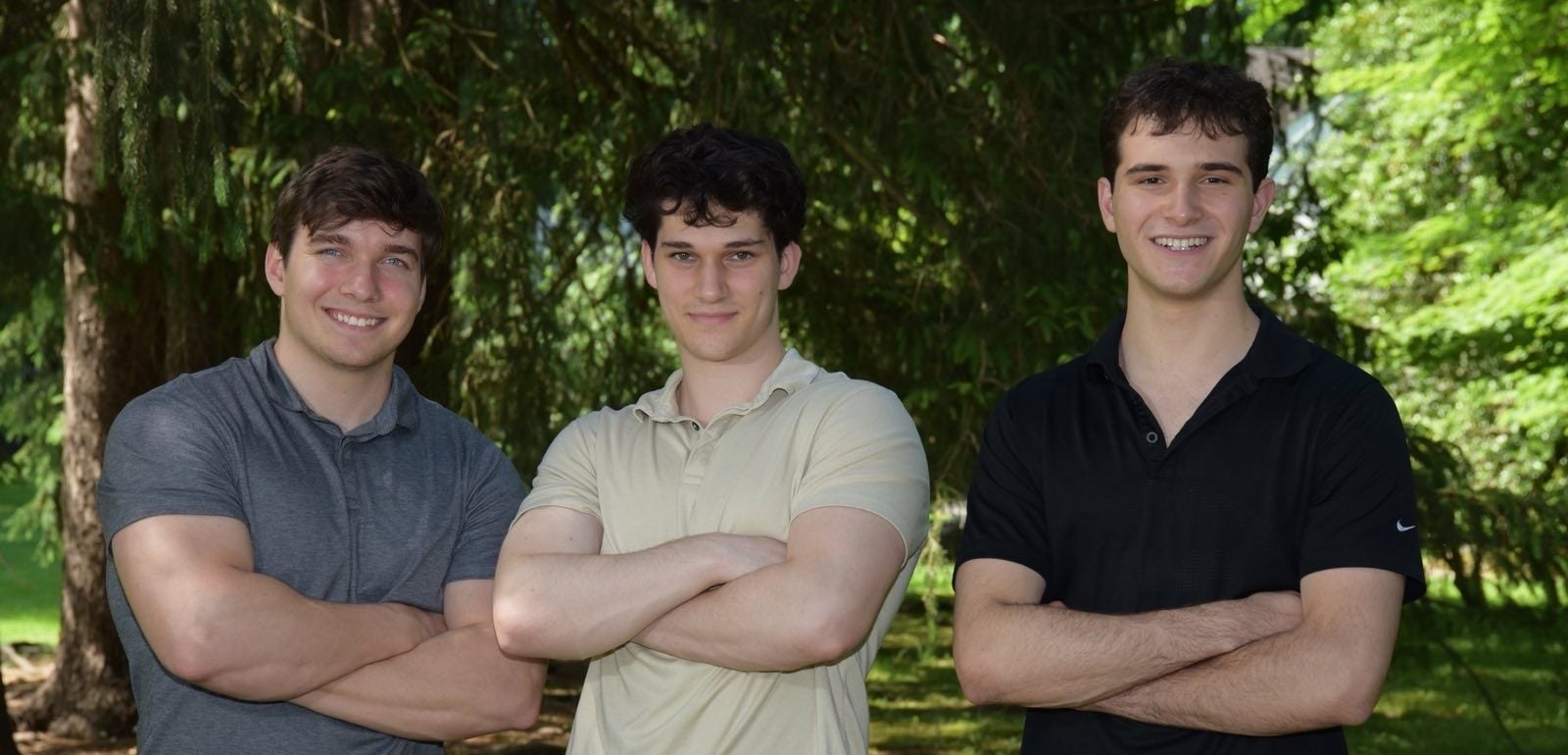 John Andrzejewski (C'25), Eli Kerstein (C'24) and Lucas Raskin wearing polo shirts and smiling at the camera