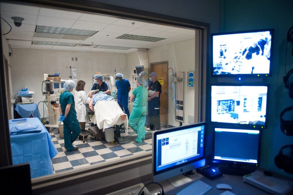 A group of doctors and nurses work in a simulated clinical setting to prepare future nurses for the real world