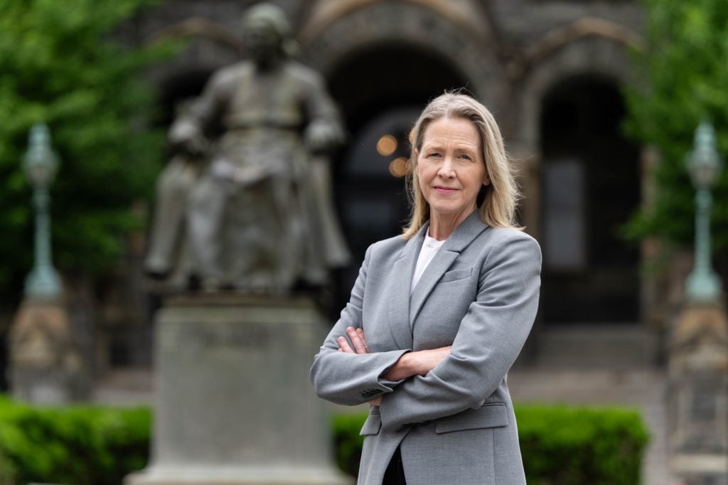 Carole Gresenz outside of Healy Hall in a gray suit