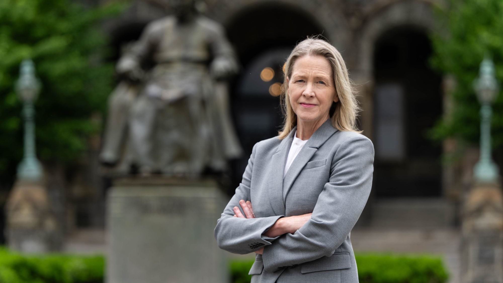 Carole Gresenz outside of Healy Hall in a gray suit