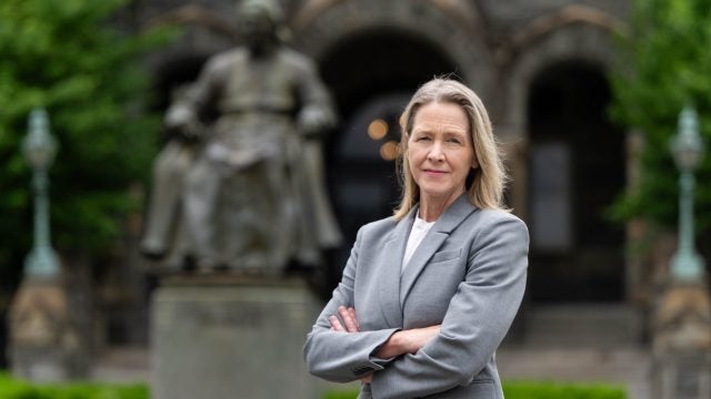 Carole Gresenz outside of Healy Hall in a gray suit