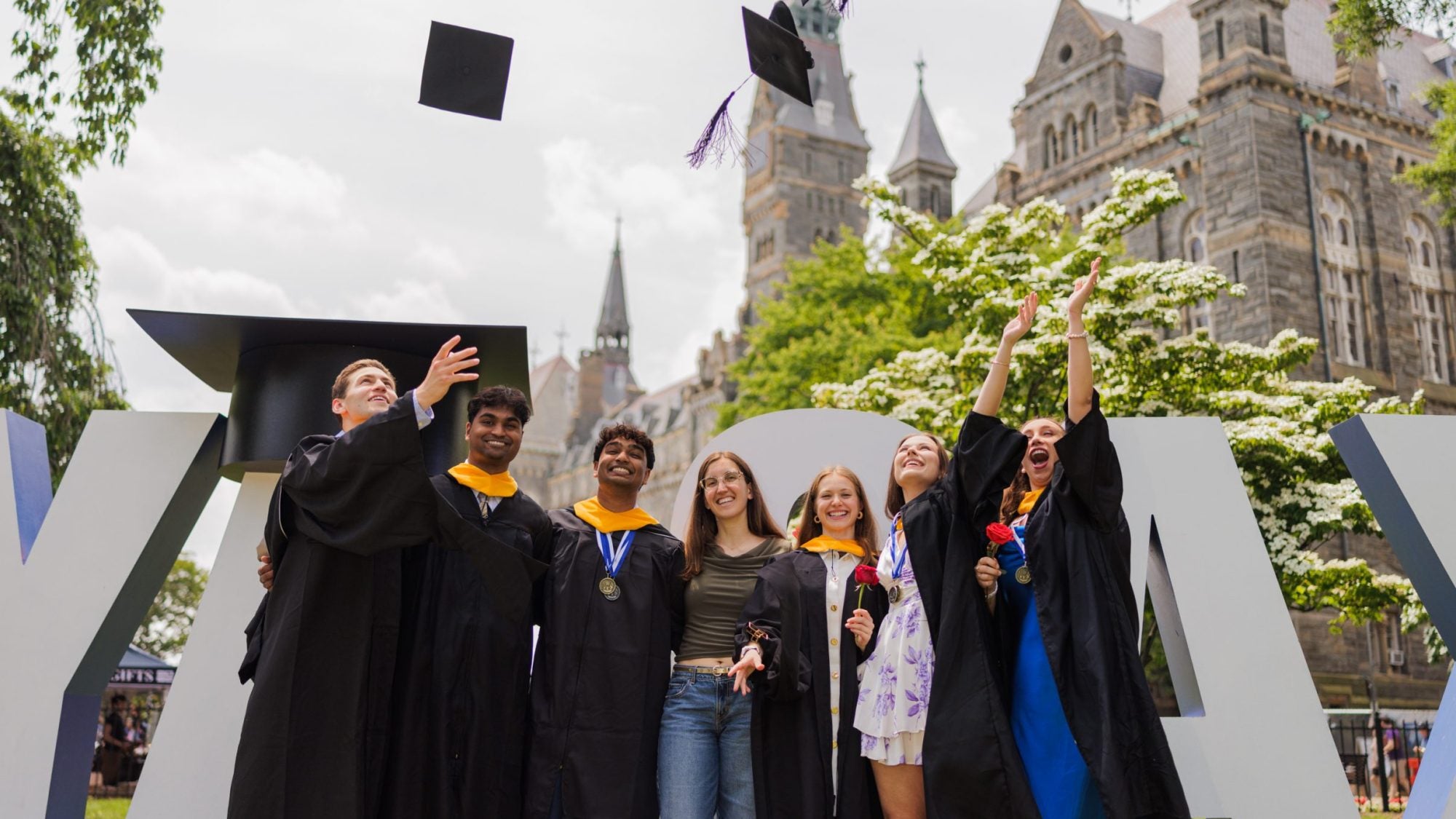 Graduates toss their caps in the air on Healy Lawn