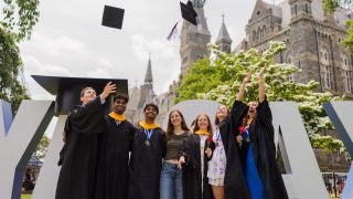 Graduates toss their caps in the air on Healy Lawn