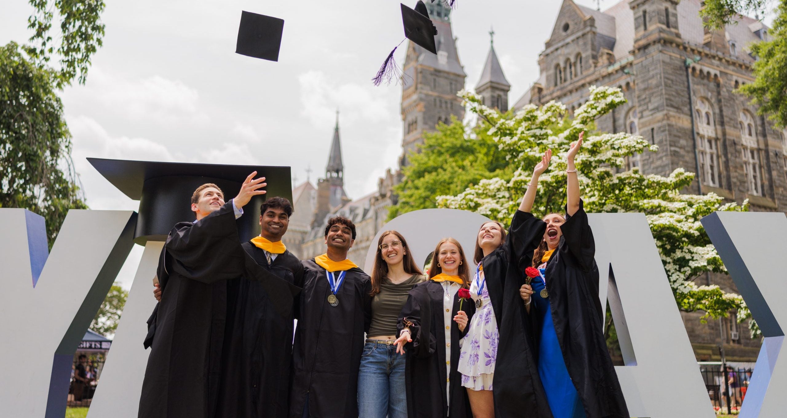 Graduates toss their caps in the air on Healy Lawn