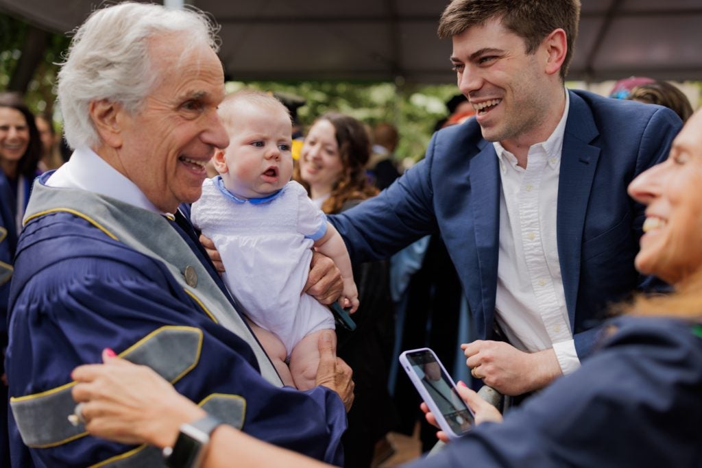 Henry Winkler holds a couple's baby and smiles