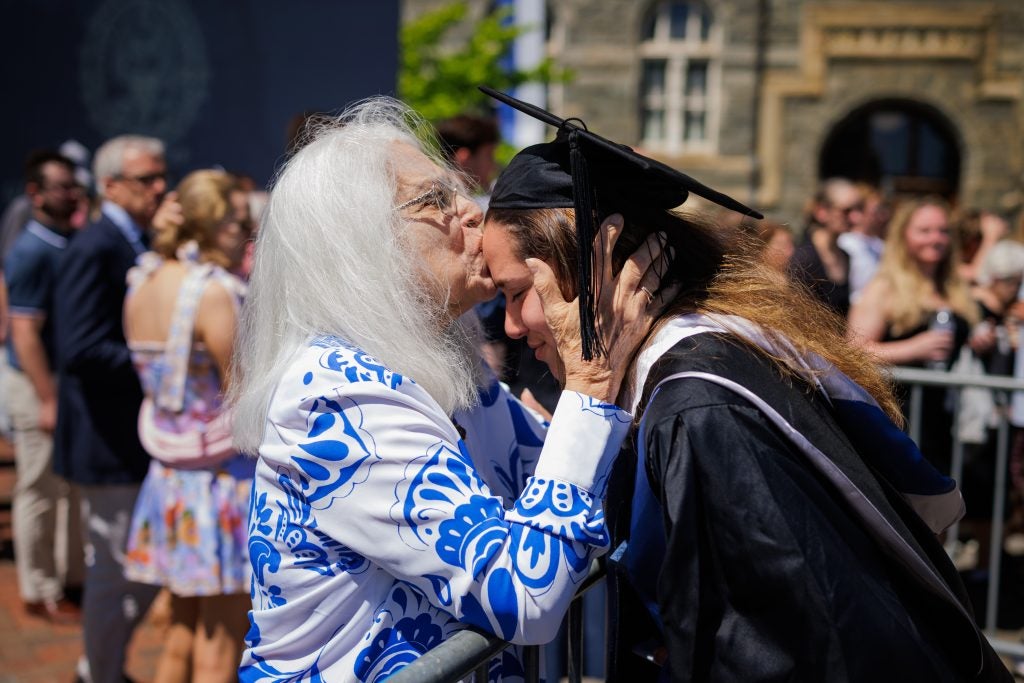 A mother kisses her graduate