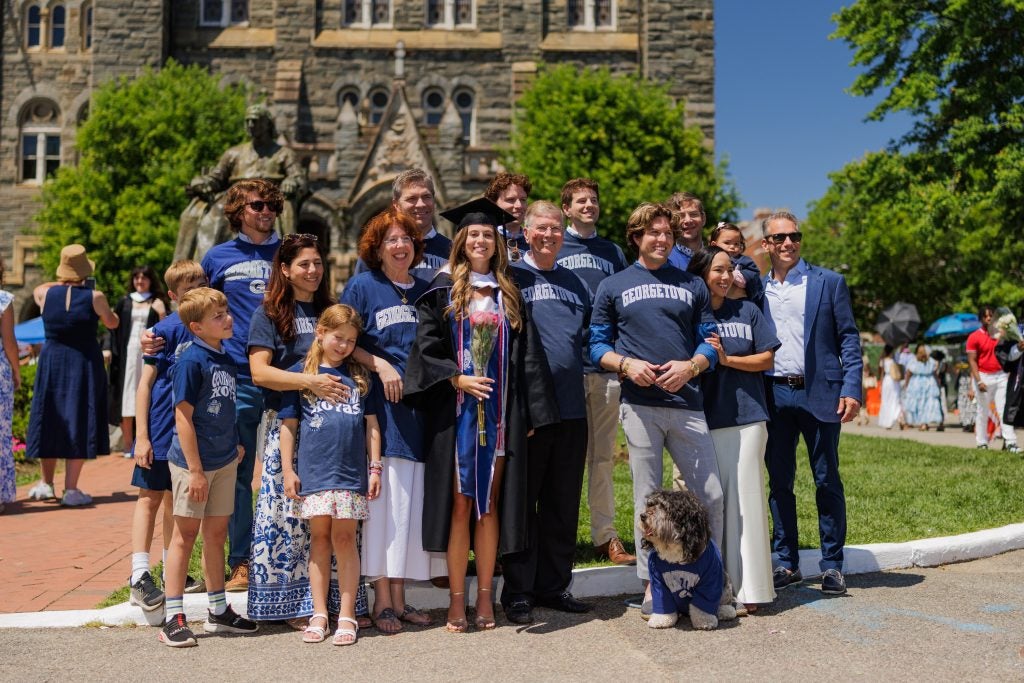 A family all in GU shirts poses with a young graduate