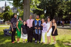 Young Black man with his family on Healy Lawn during graduation.