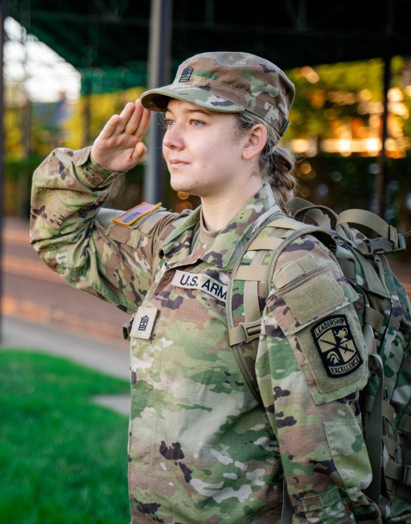 Young white woman salutes in an Army uniform