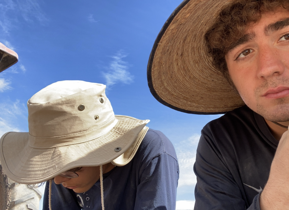Two men with hats take a selfie on a sunny day