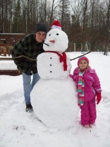 Lisa with her father with a snowman
