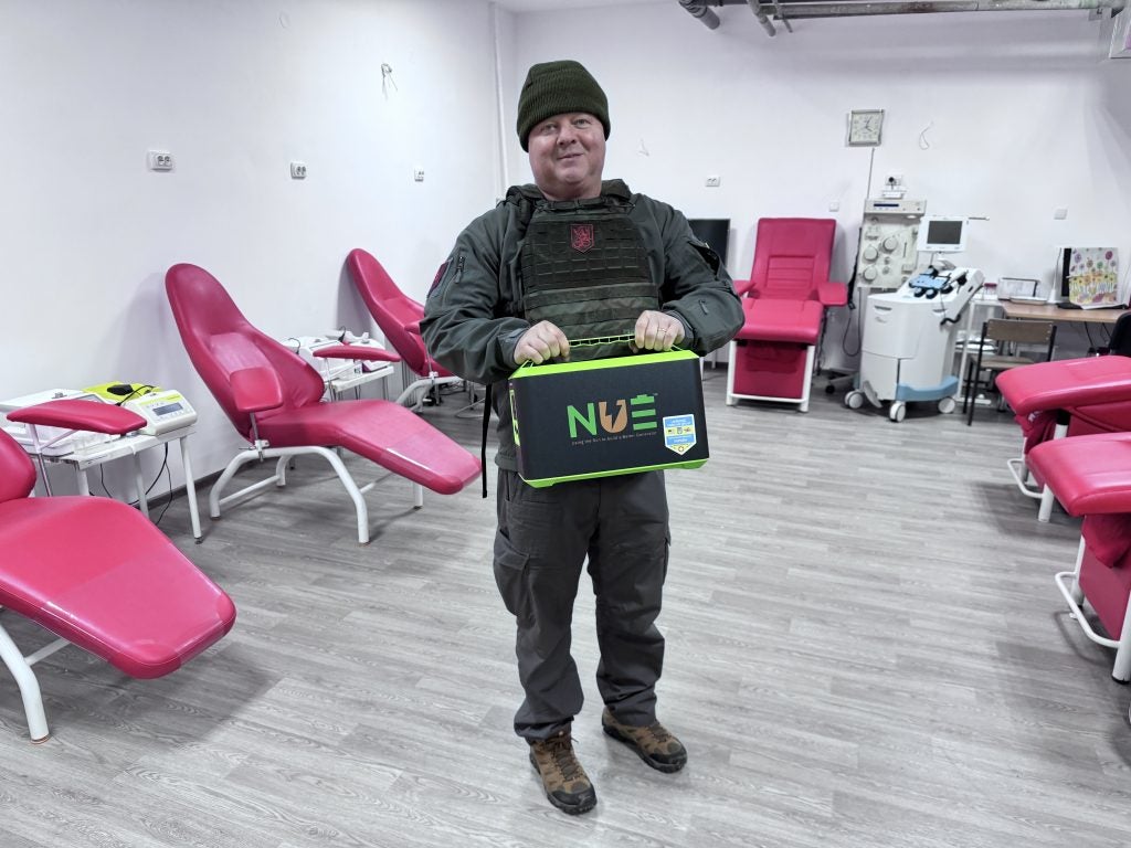 Himmer in body armor carrying a portable power unit