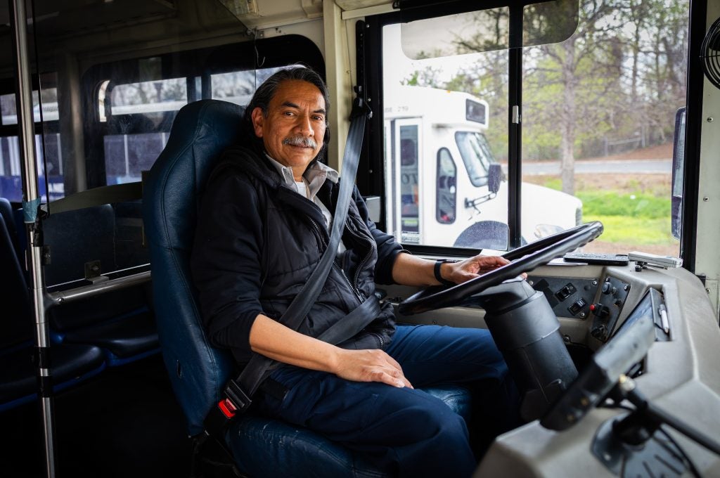 Robinson at the wheel of a GUTS bus