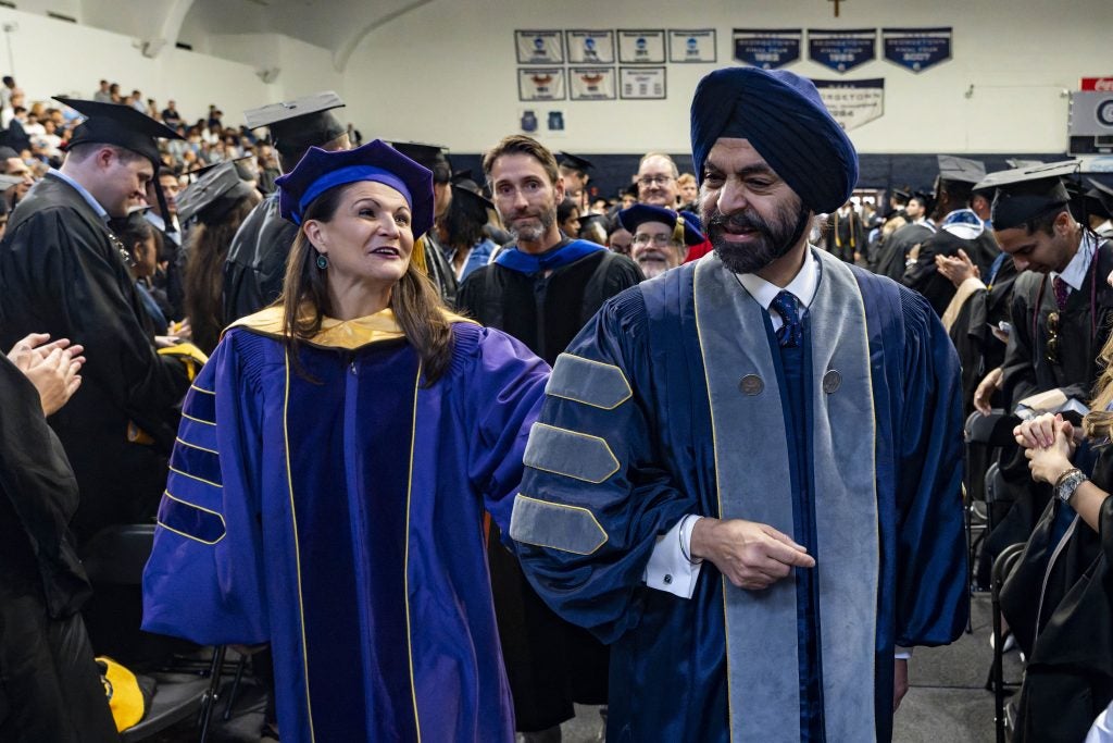 Two people in graduation gowns process into Georgetown's graduation ceremony