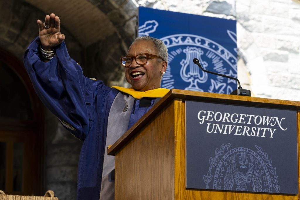 Black woman in glasses delivers a commencement speech