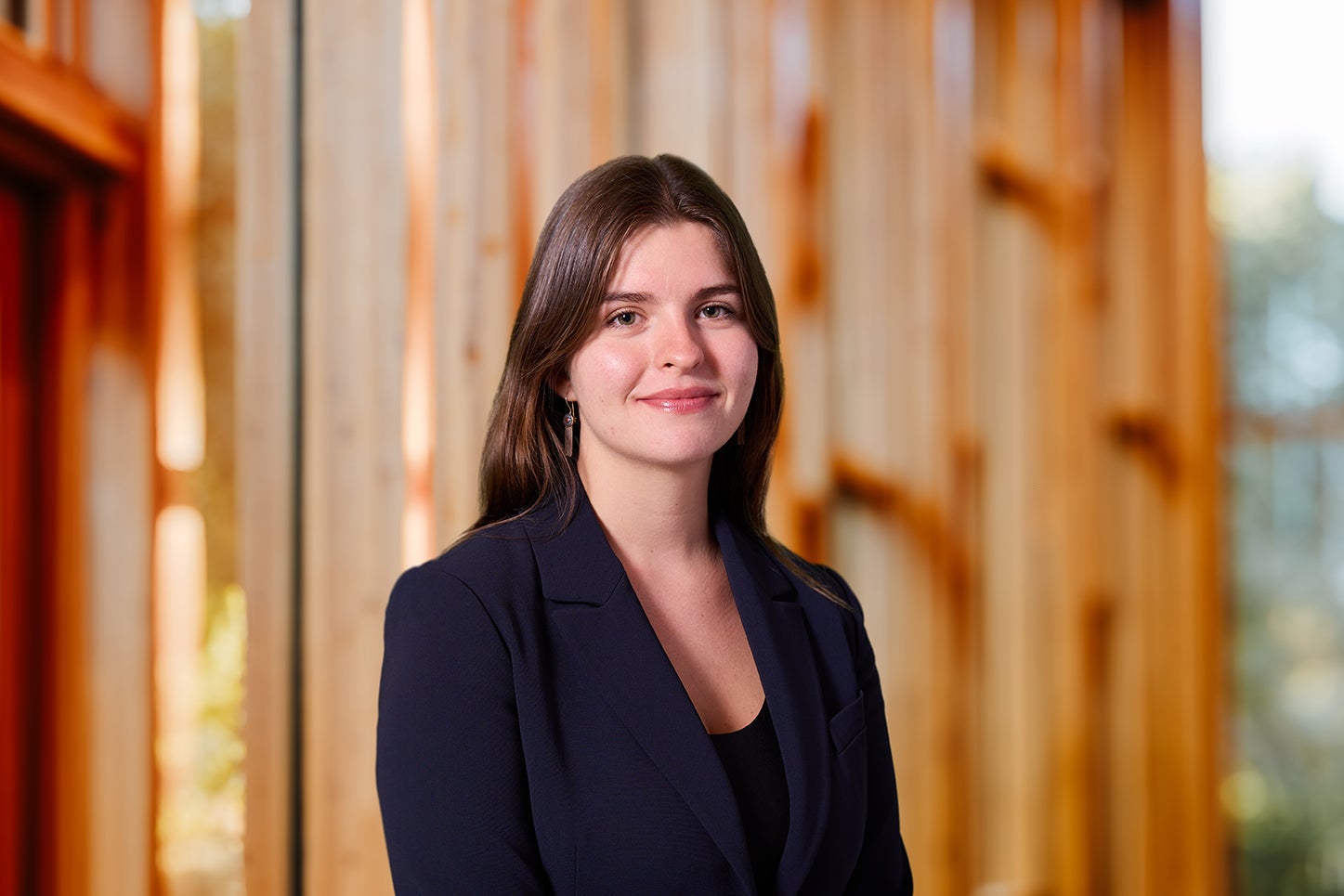 A woman with brown hair and a black blazer smiles