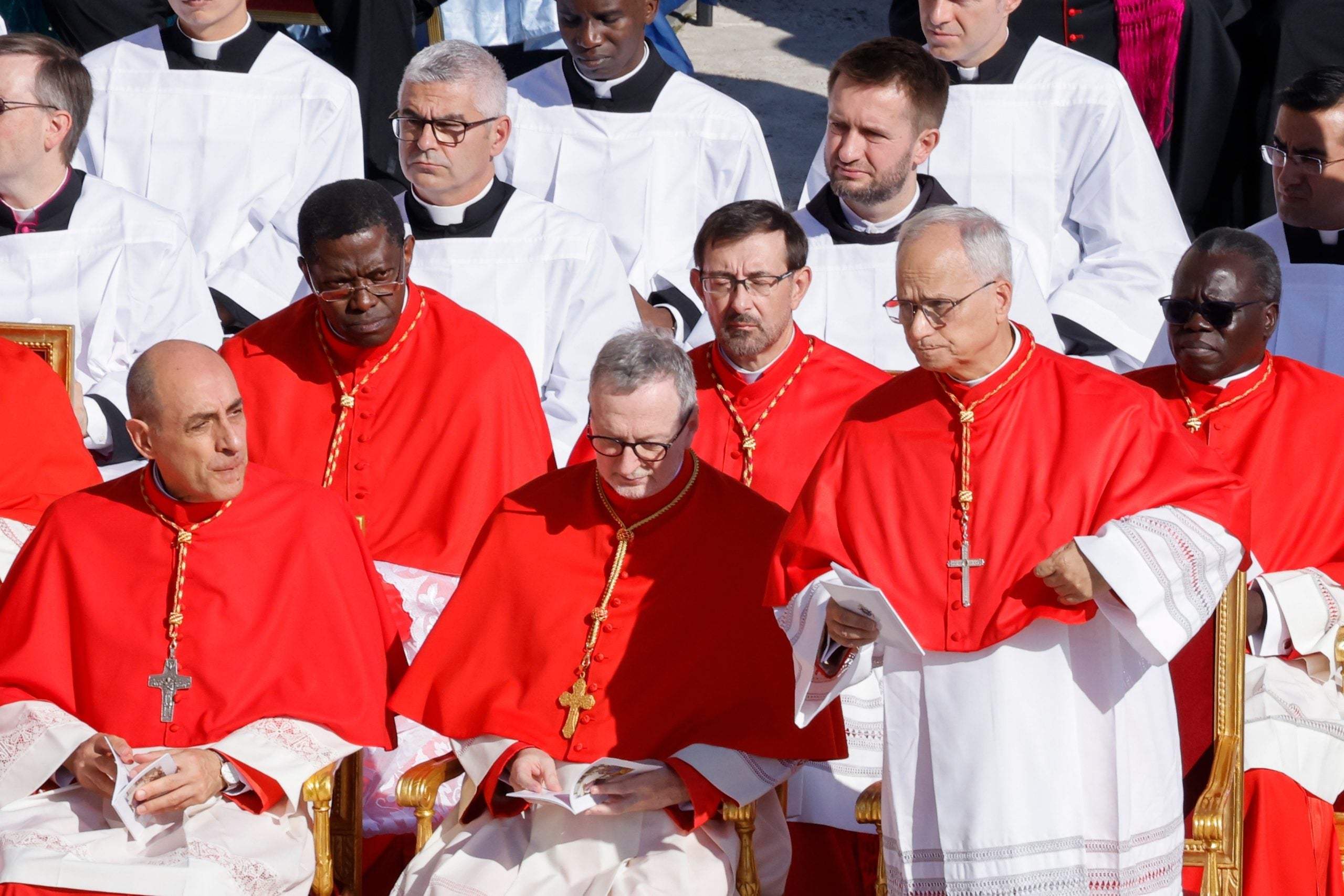 A group of cardinals of red robes talk together