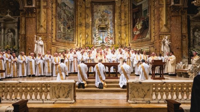 Five candidates for ordination kneel before the altar and other priests