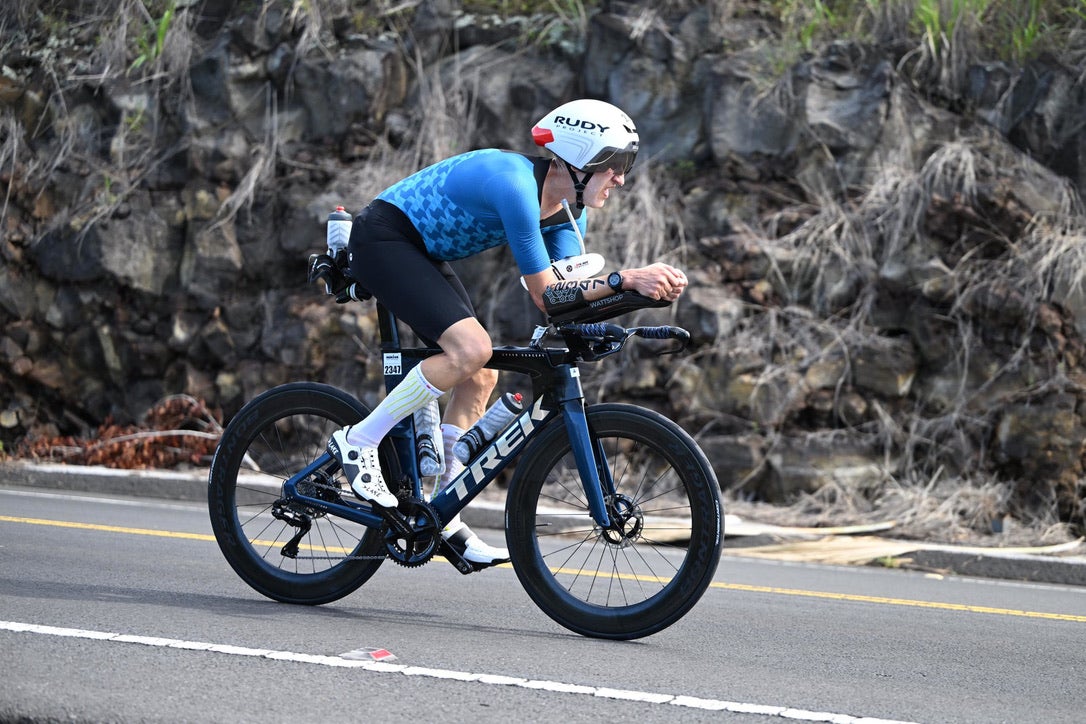 A man in a helmet and blue biking gear cycles during the Ironman World Championship in Kona, Hawaii.