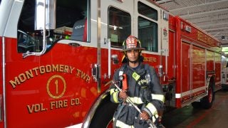 Tharun in firefighting gear next to a firetruck