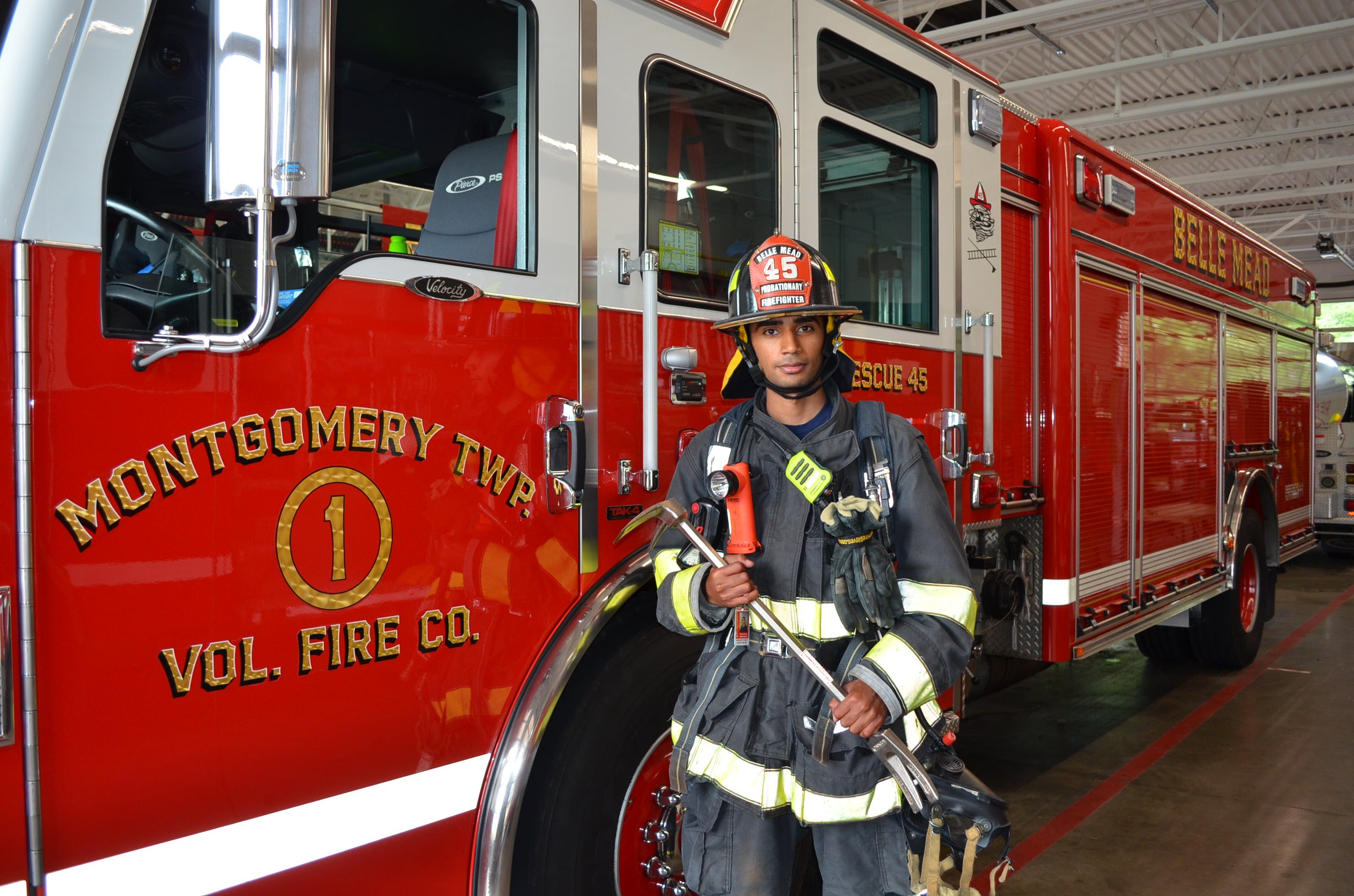 Tharun in firefighting gear next to a firetruck