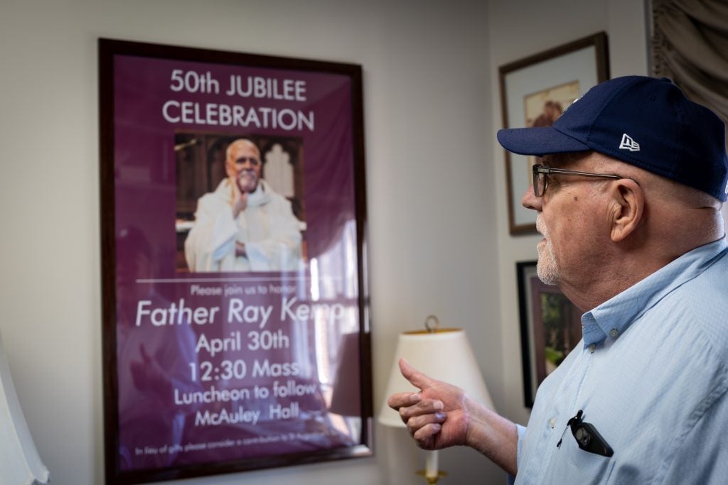 Ray Kemp stares at a poster celebrating his jubilee year as a priest