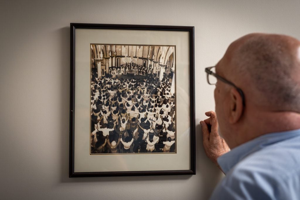 Ray Kemp looks at a black and white photo inside a parish during Mass