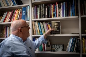 Ray Kemp places a book on MLK on a shelf