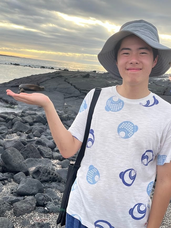Jeremy in the Galapagos in a white shirt with a sea lion in the background