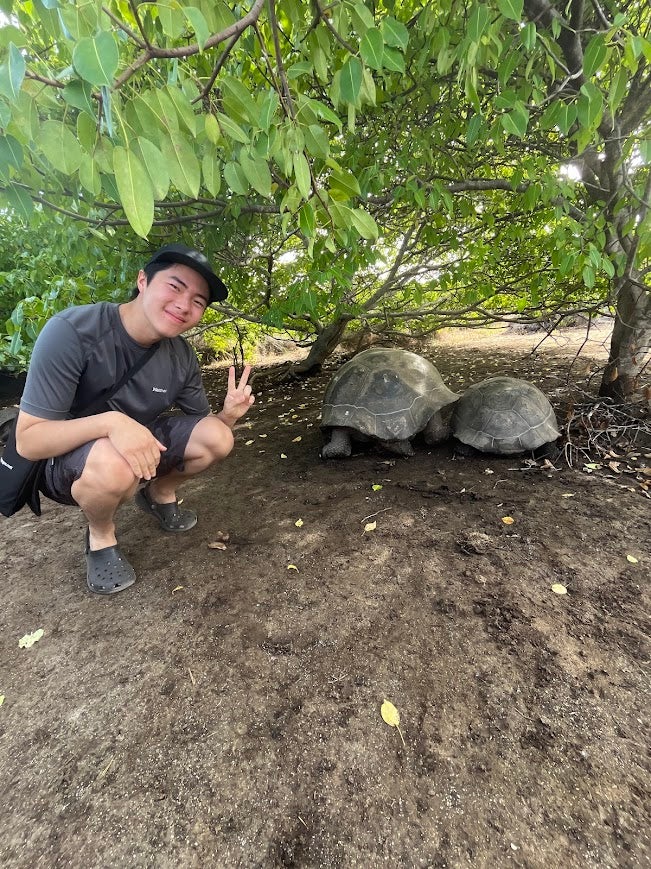 Jeremy with two turtles in the Galapagos