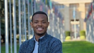 Portrait of Obinna in a blue sweater at the UN