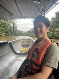 Jeremy in a life vest while traveling in a boat on a river in the Amazon