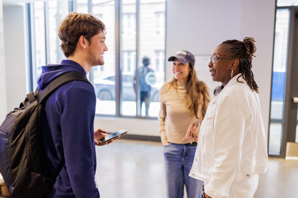 A male student smiles as he talks to a chaplain 