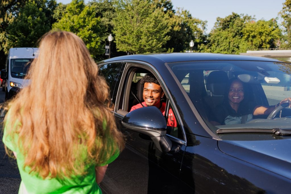 A new student smiles from his car as he arrives at Georgetown