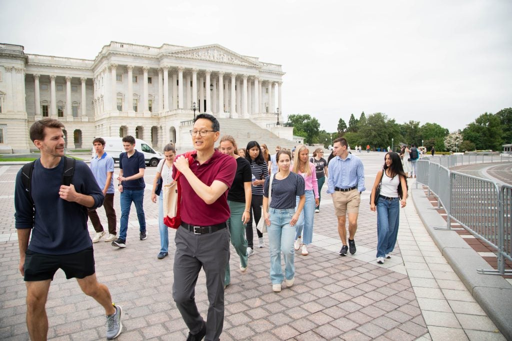 A group of people walk past the Supreme Court
