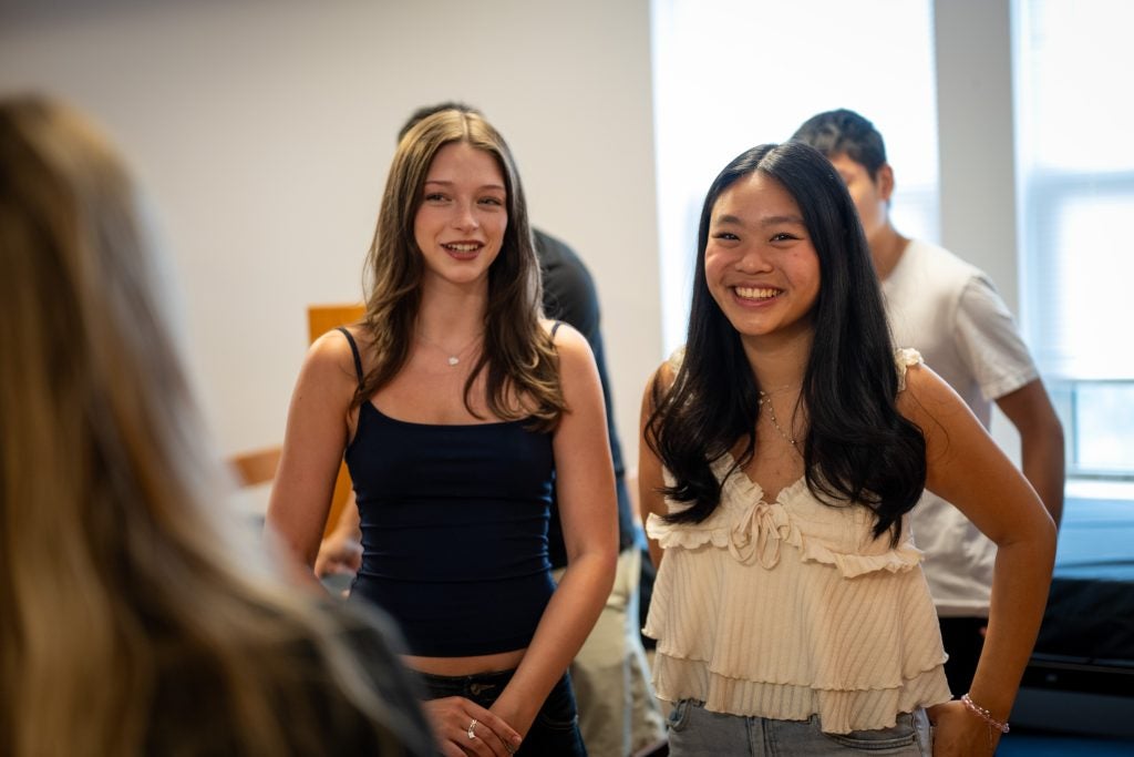 Two students smile in their new dorm room