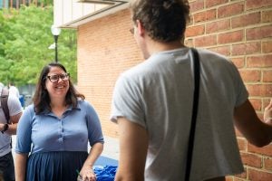 Mollie speaks with a student outside a dorm building