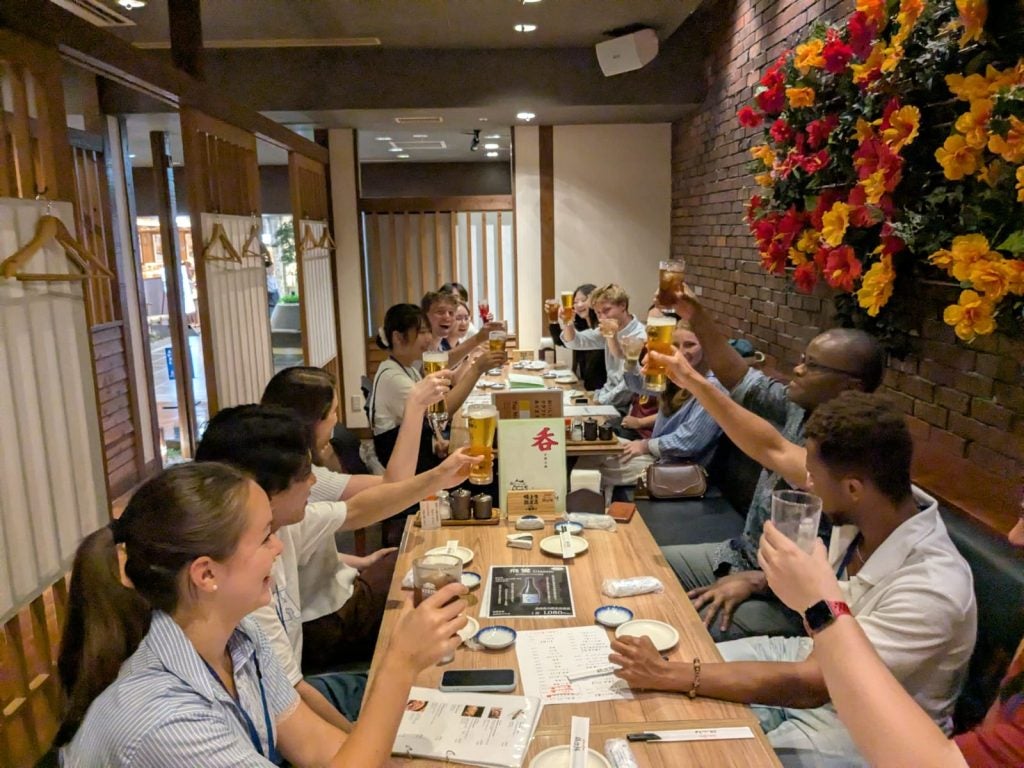 Students at a Japanese restaurant raise their glasses