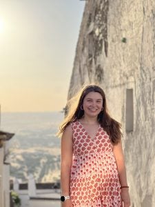 Caroline Sewell in a red dress at sunset in Portugal