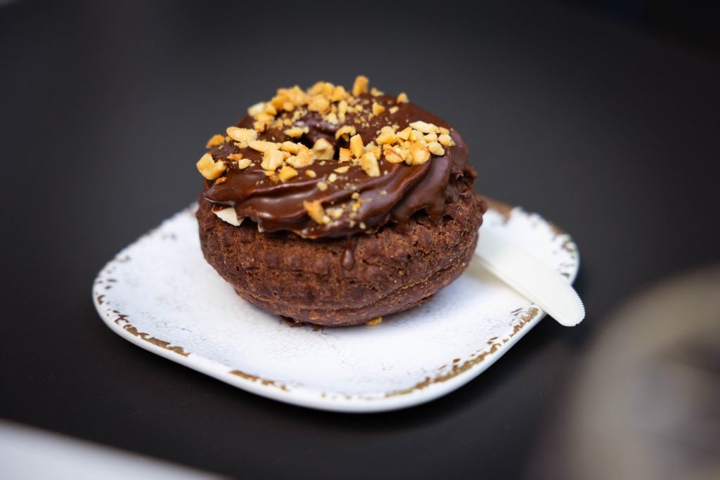 A chocolate peanut butter donut on a white plate